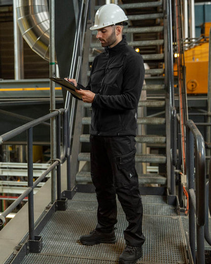 Black Coloured Mascot Workwear Mens Accelerate Fleece Jacket on factory background 