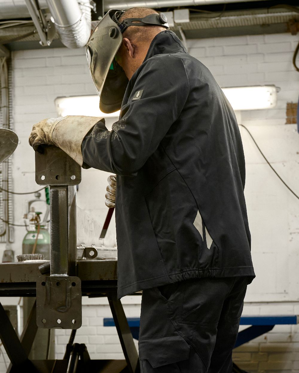 Black Mascot Workwear Mens Accelerate Jacket on factory background 