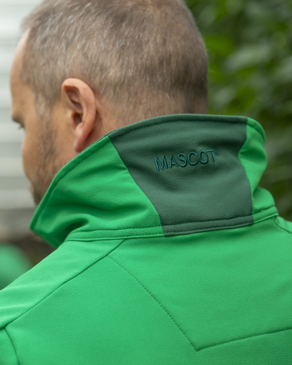Grass Green Coloured Mascot Workwear Mens Accelerate Lightweight Jacket on farm background 
