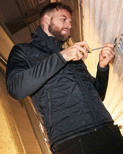 Black Coloured Mascot Workwear Mens Accelerate Lightweight Thermal Gilet on construction background 
