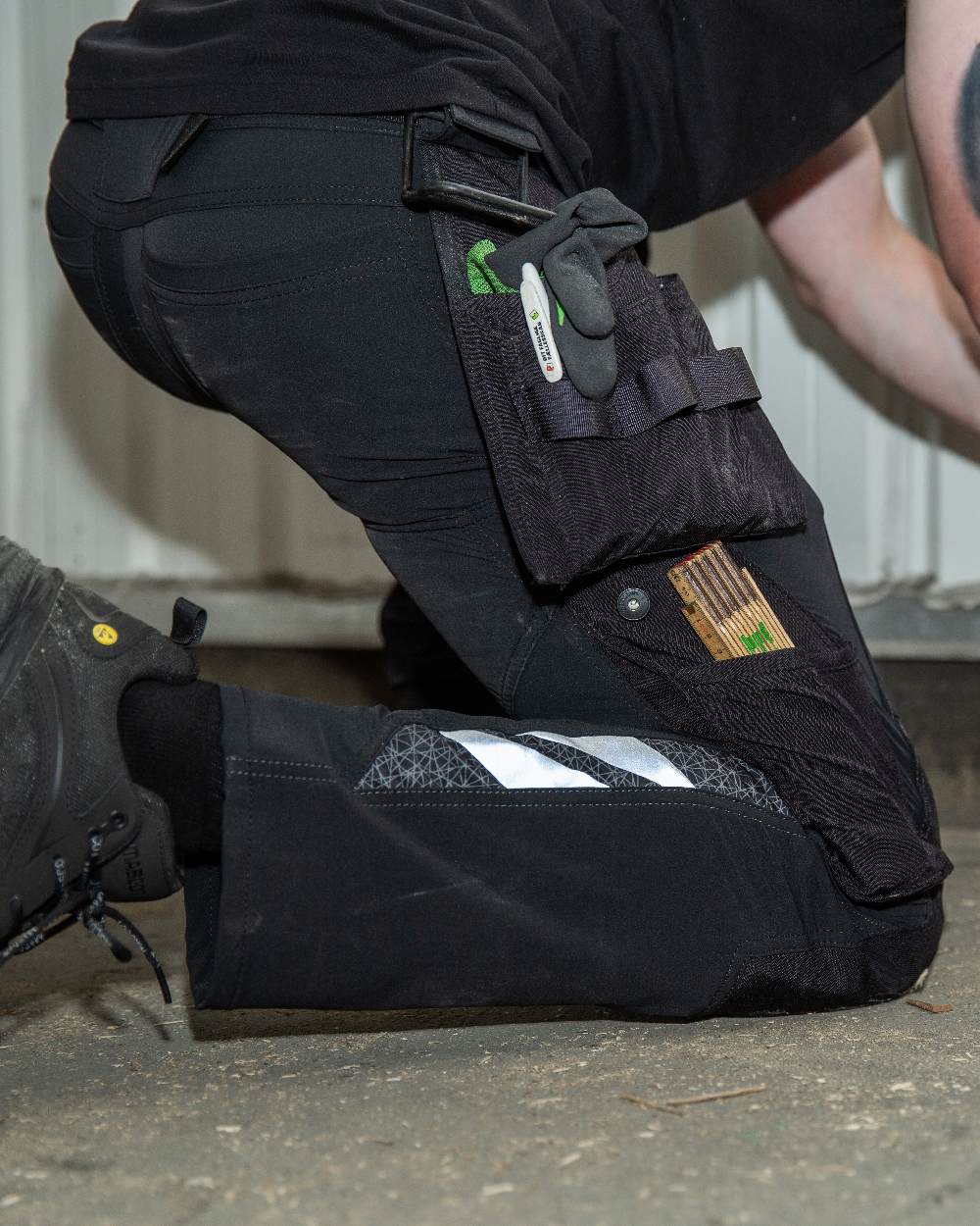 Black Coloured Mascot Workwear Mens Accelerate Lightweight Trousers With Holster Pockets on factory background 