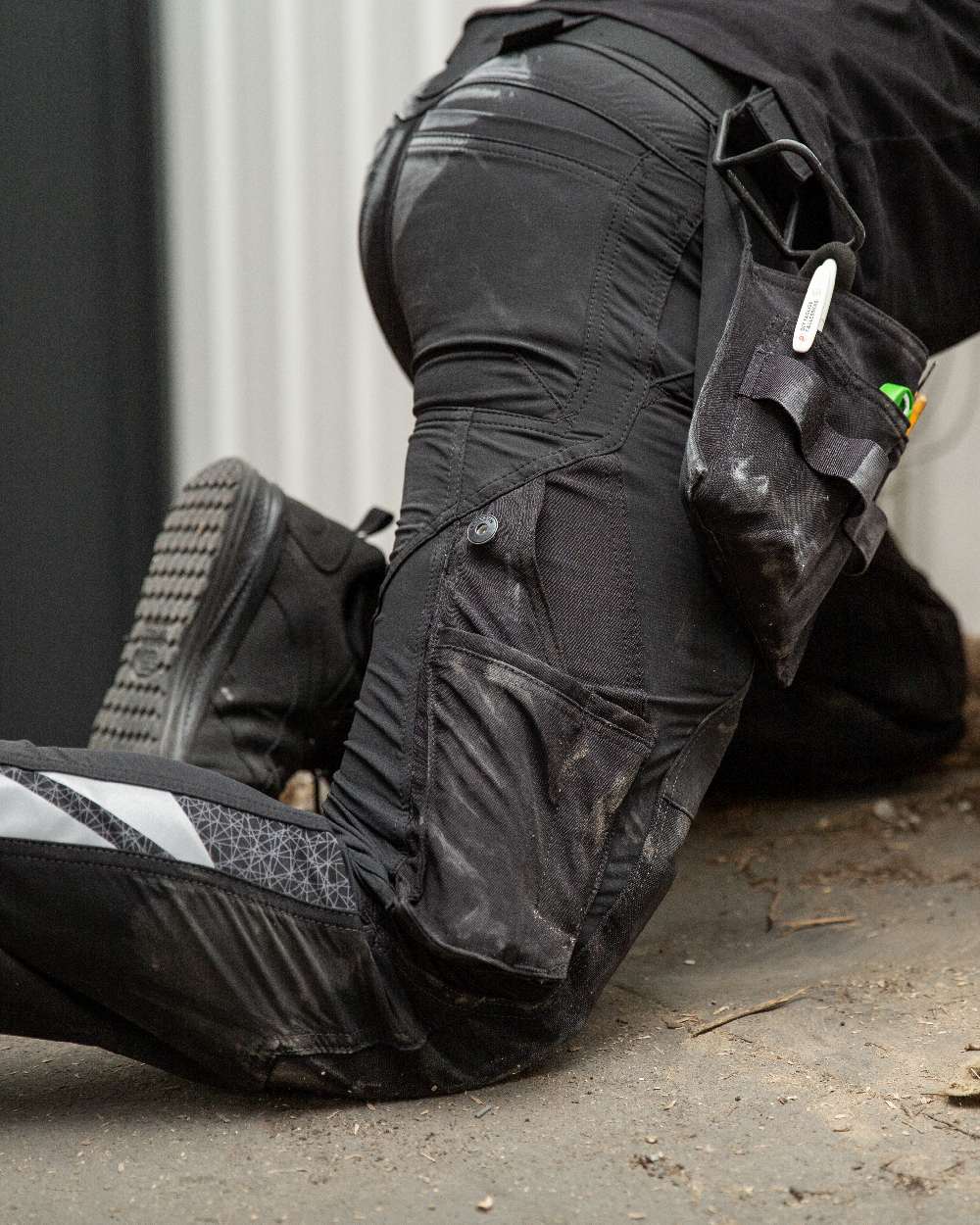 Black Coloured Mascot Workwear Mens Accelerate Lightweight Trousers With Holster Pockets on factory background 