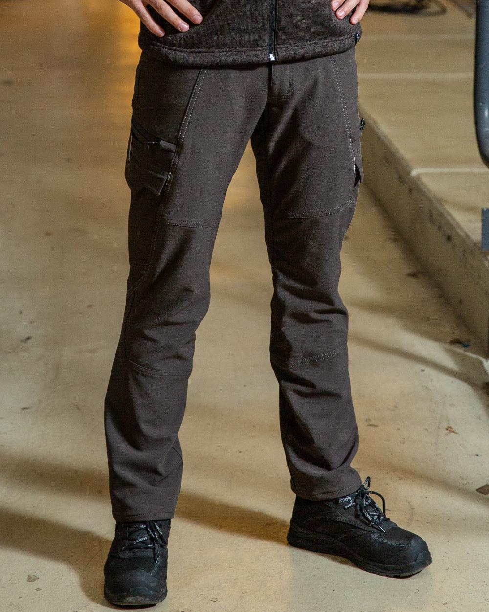 Dark Anthracite Coloured Mascot Workwear Mens Accelerate Lightweight Trousers With Thigh Pockets on factory background 