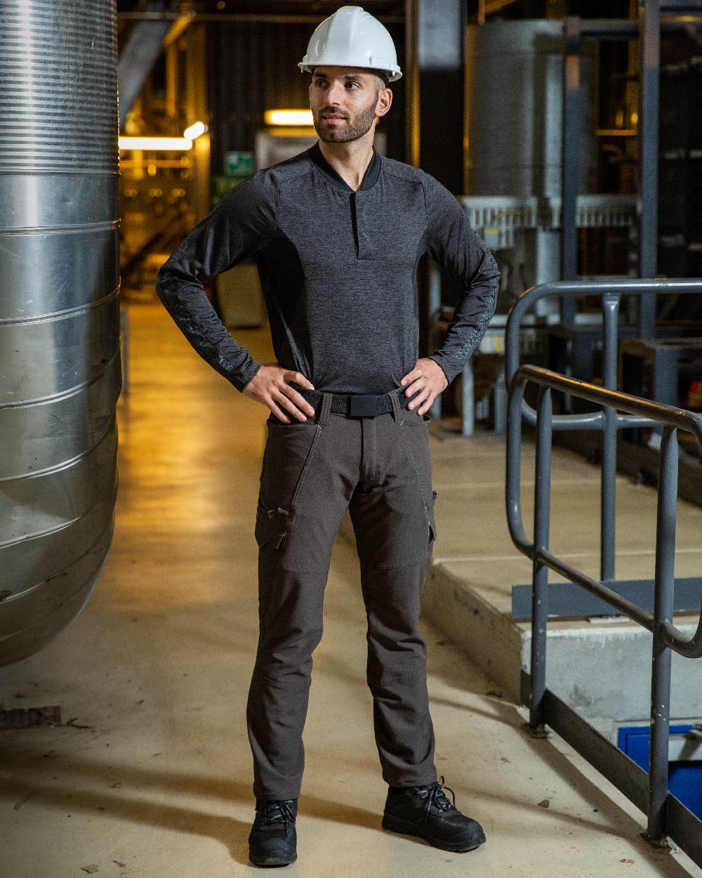 Dark Anthracite Coloured Mascot Workwear Mens Accelerate Lightweight Trousers With Thigh Pockets on factory background 