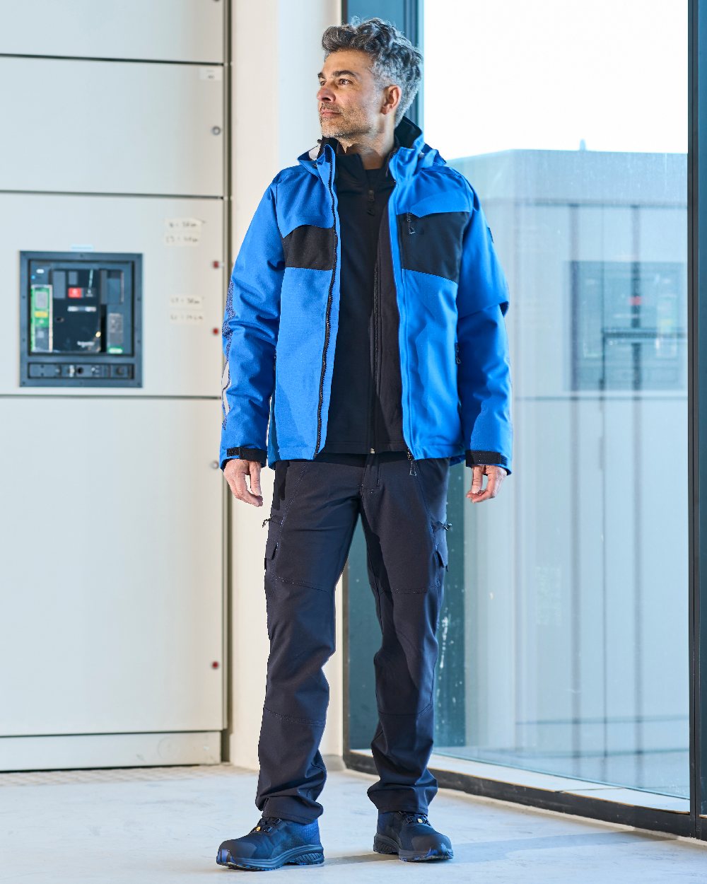Dark Navy Coloured Mascot Workwear Mens Accelerate Lightweight Trousers With Thigh Pockets on factory background 