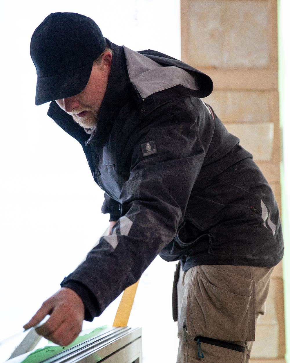 Black Coloured Mascot Workwear Mens Accelerate Outer Shell Jacket on construction background 