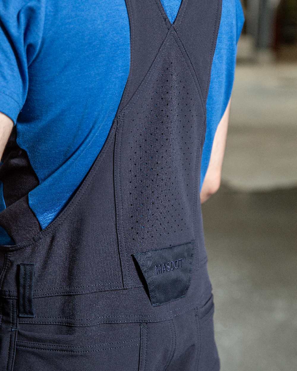 Dark Navy Coloured Mascot Workwear Mens Accelerate Stretch Zones Bib &amp; Brace With Kneepad Pockets on factory background 