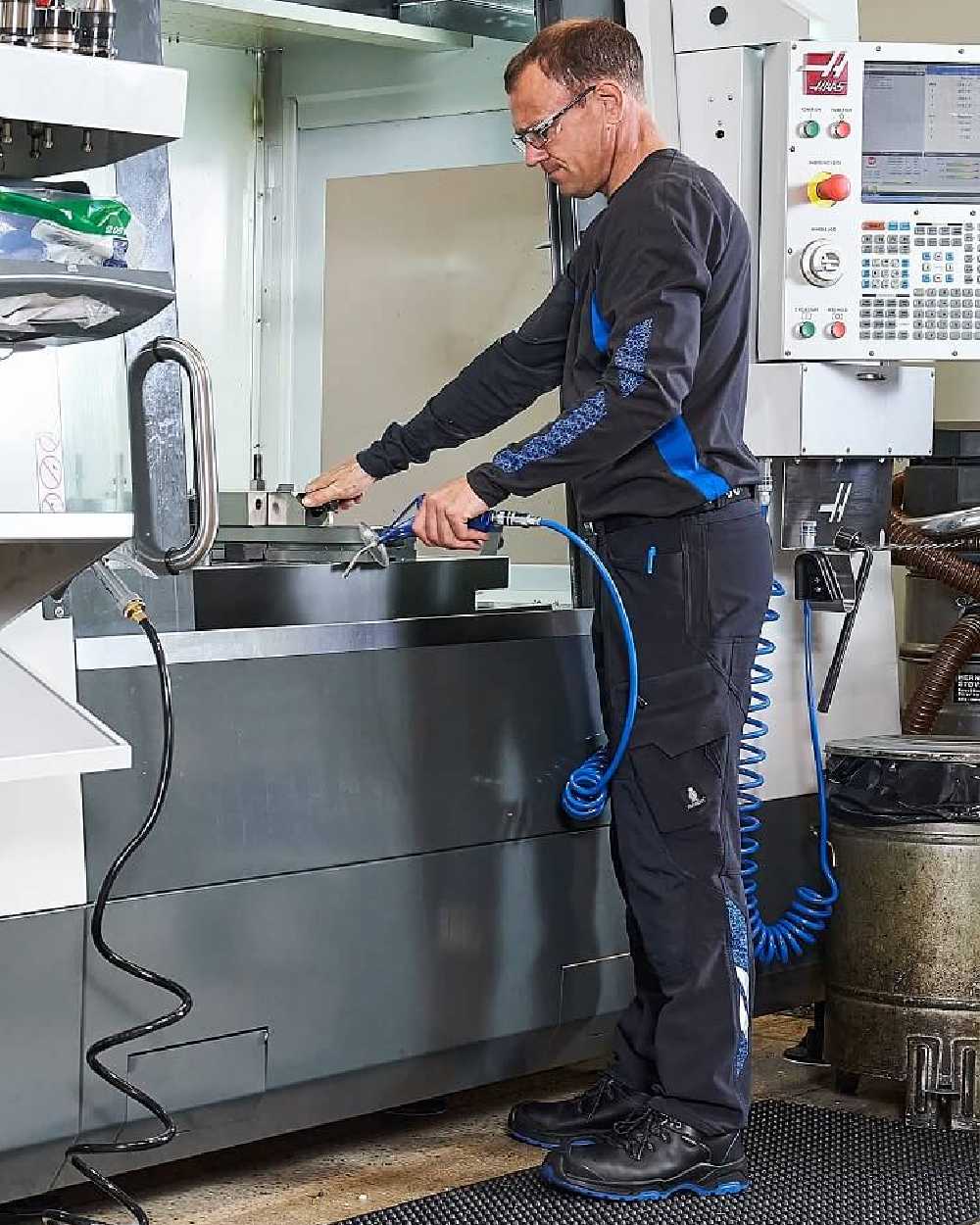 Dark Navy Coloured Mascot Workwear Mens Accelerate Ultimate Stretch Lightweight Trousers on factory background 