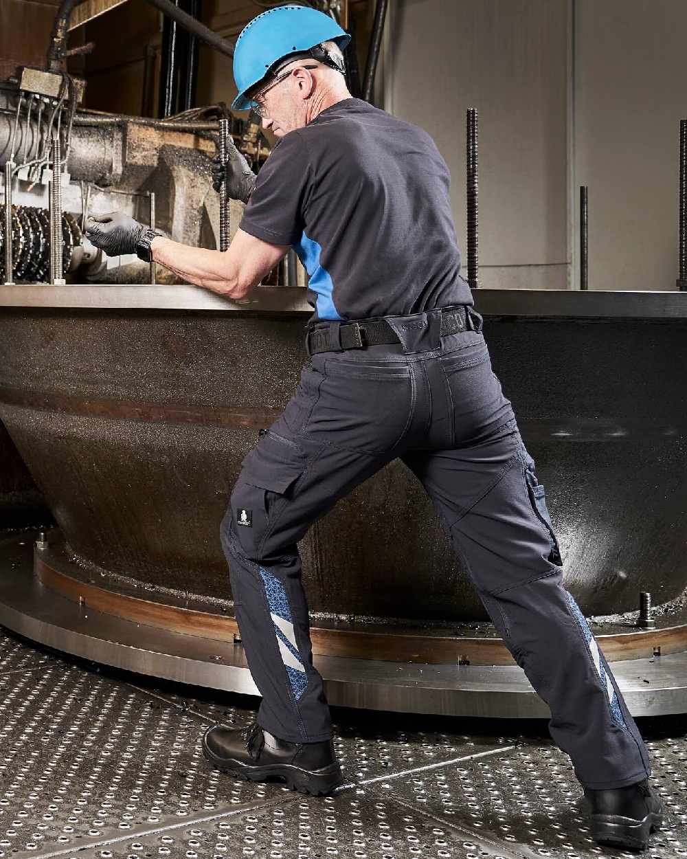 Dark Navy Coloured Mascot Workwear Mens Accelerate Ultimate Stretch Lightweight Trousers on factory background 