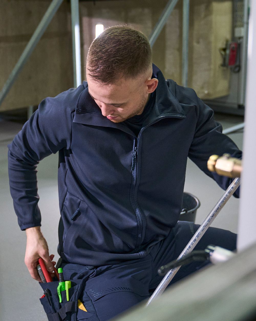 Dark Navy Coloured Mascot Workwear Mens Customized Full Zip Fleece Jumper on construction background 