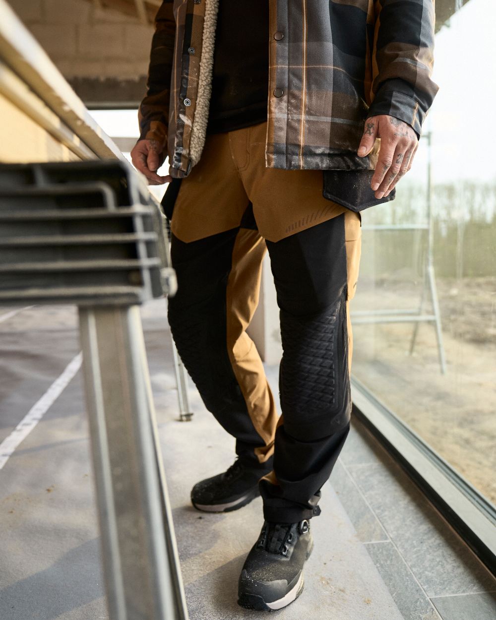 Nut Brown Black Coloured Mascot Workwear Mens Customized Ultimate Stretch Trousers on construction background 