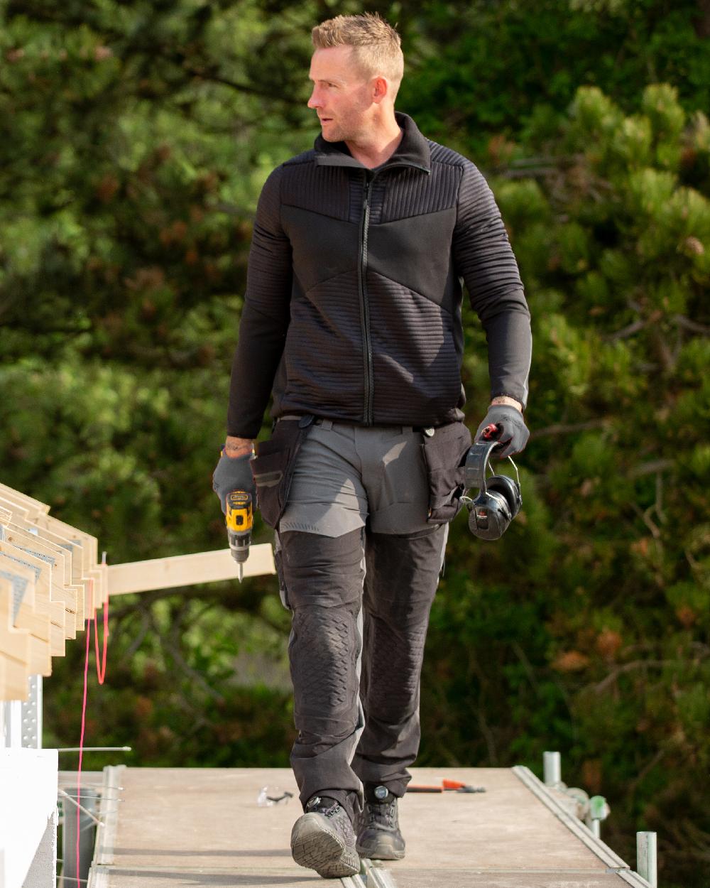 Stone Grey Black Coloured Mascot Workwear Mens Customized Ultimate Stretch Trousers on construction background 