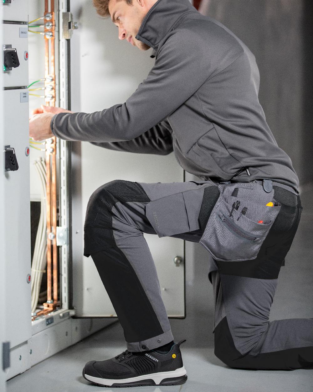 Stone Grey Black Coloured Mascot Workwear Mens Customized Ultimate Stretch Trousers on construction background 