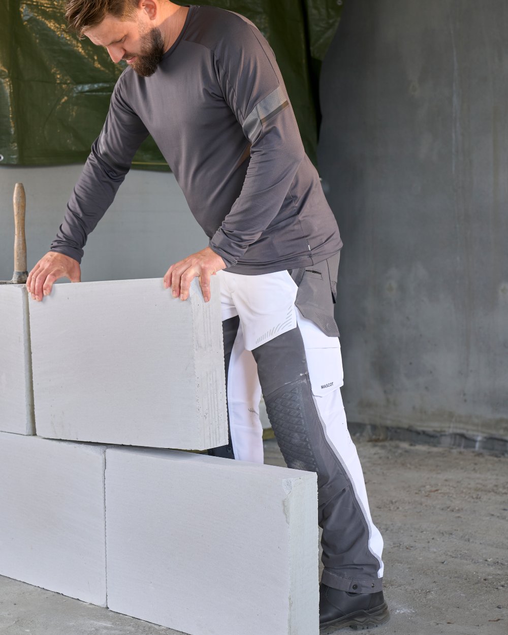 White Stone Grey Coloured Mascot Workwear Mens Customized Ultimate Stretch Trousers on construction background 