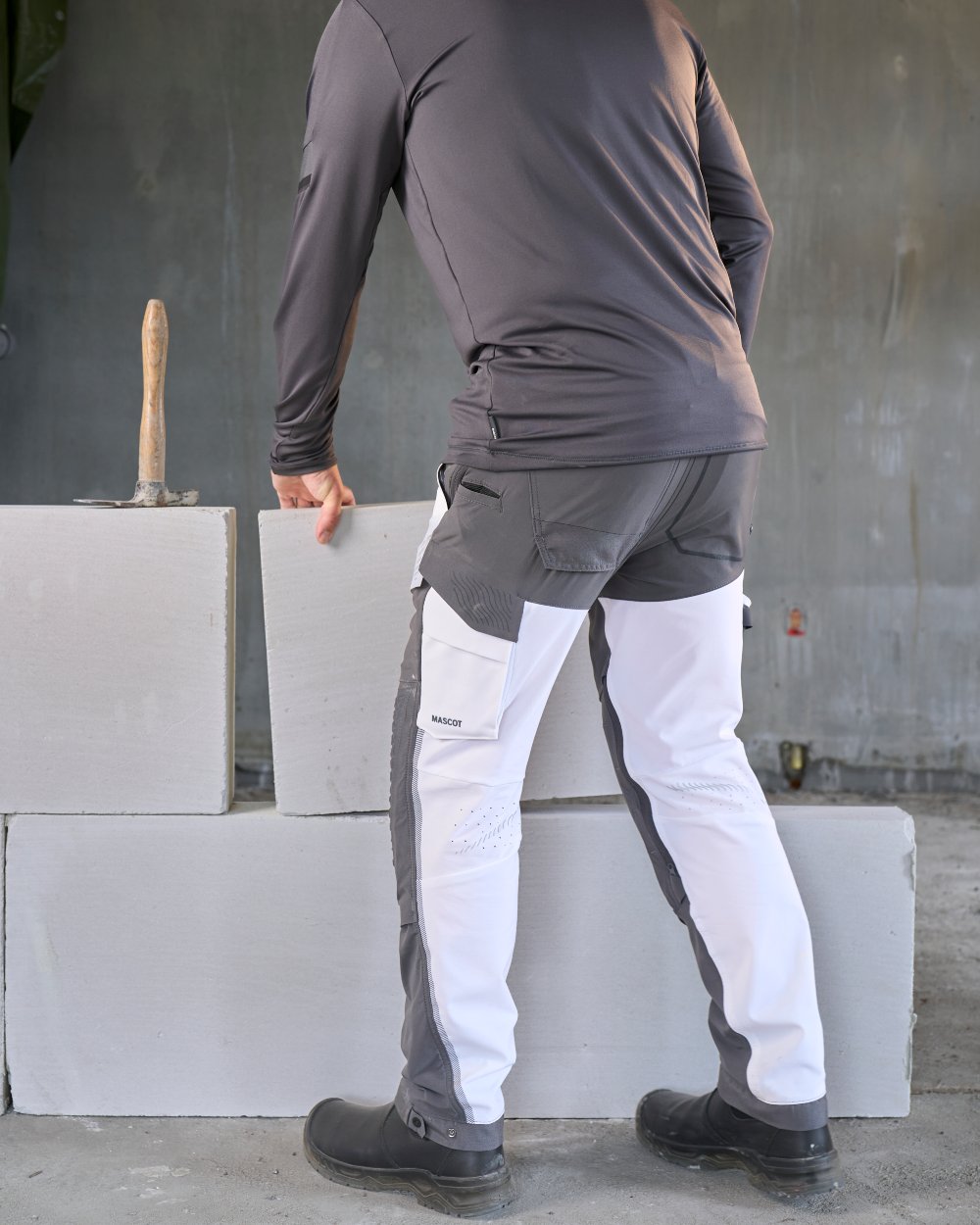 White Stone Grey Coloured Mascot Workwear Mens Customized Ultimate Stretch Trousers on construction background 