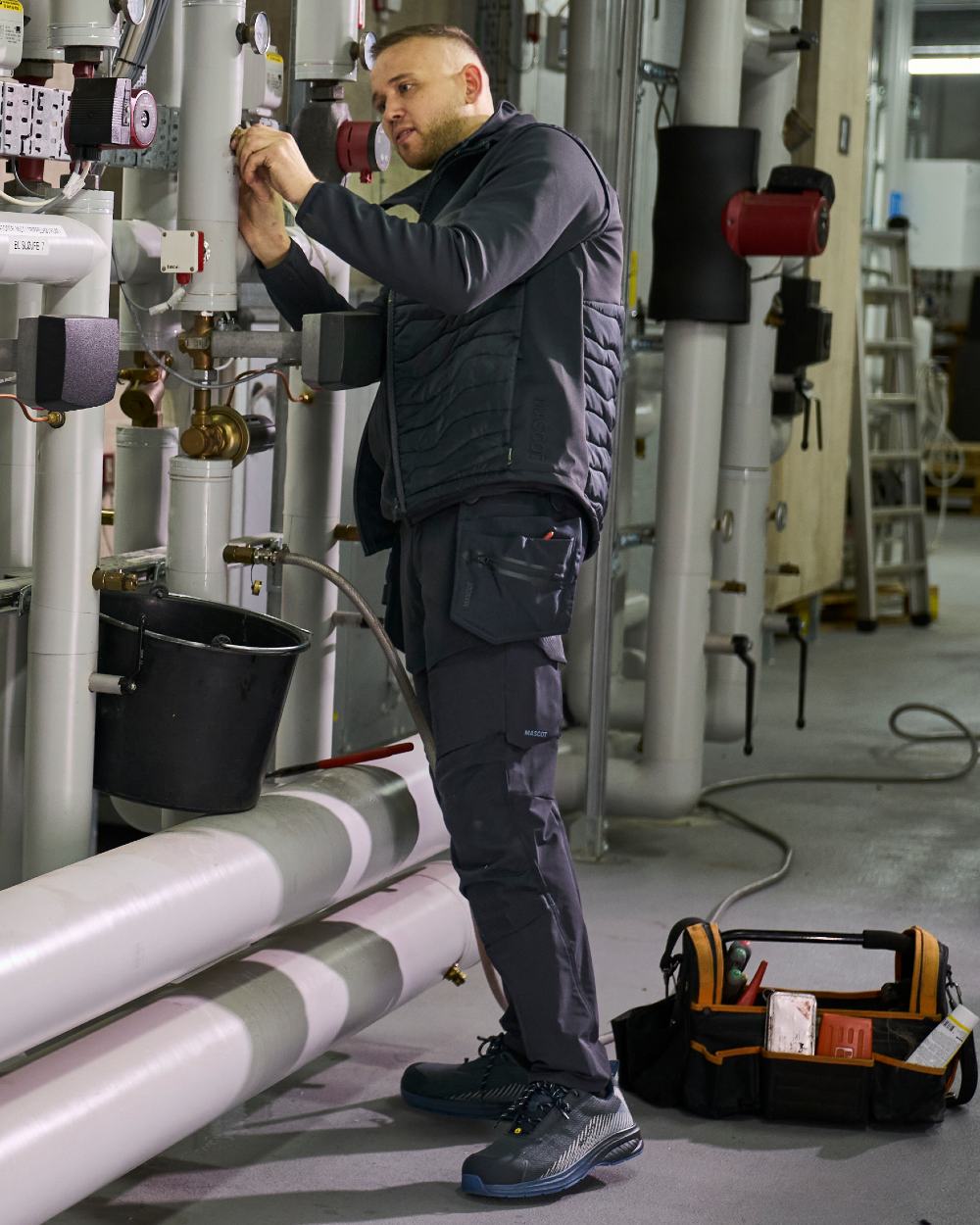 Dark Navy Coloured Mascot Workwear Mens Customized Ultimate Stretch Trousers With Kneepad Pockets on construction background 