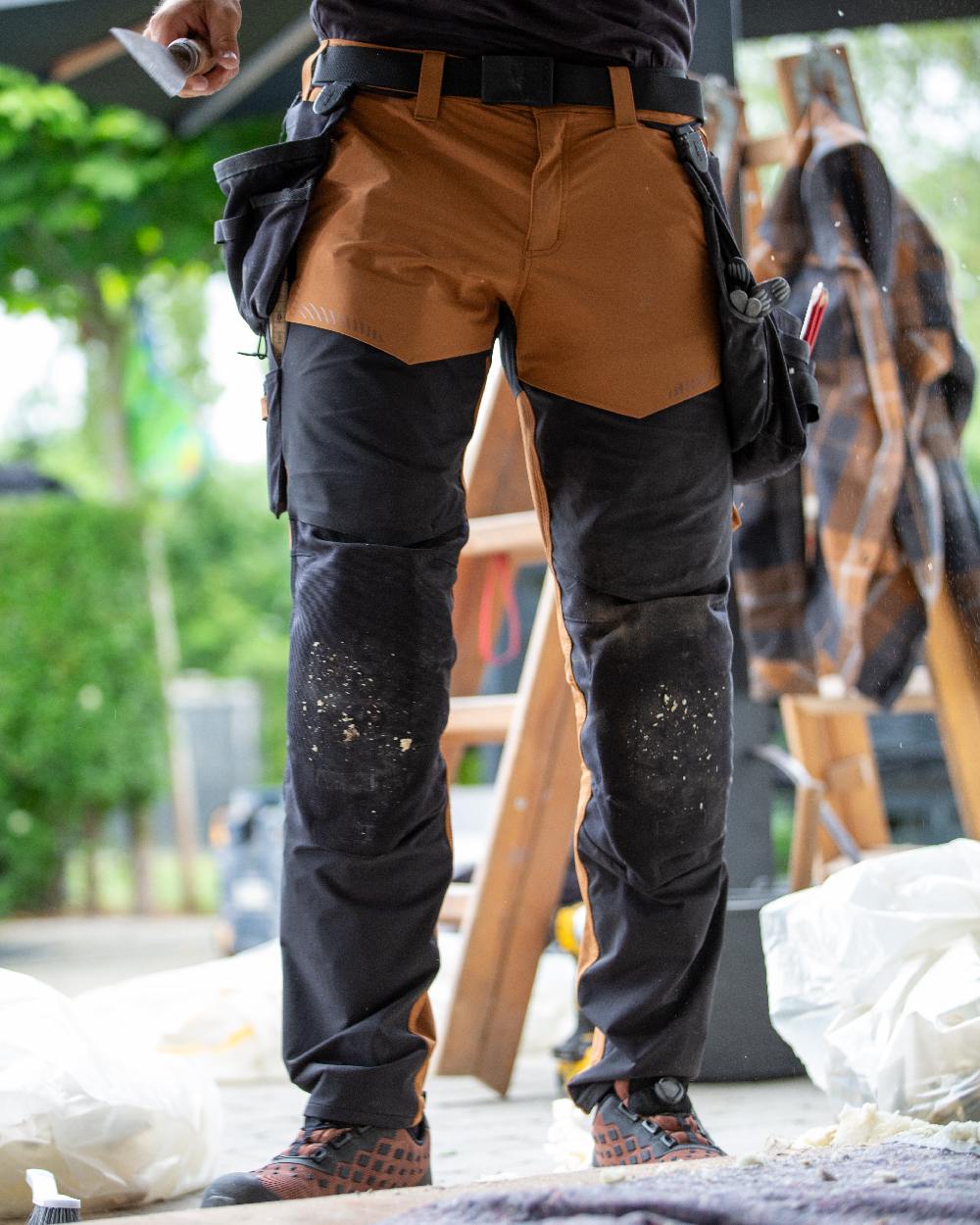 Nut Brown Black Coloured Mascot Workwear Mens Customized Ultimate Stretch Trousers With Kneepad Pockets on outdoor background 