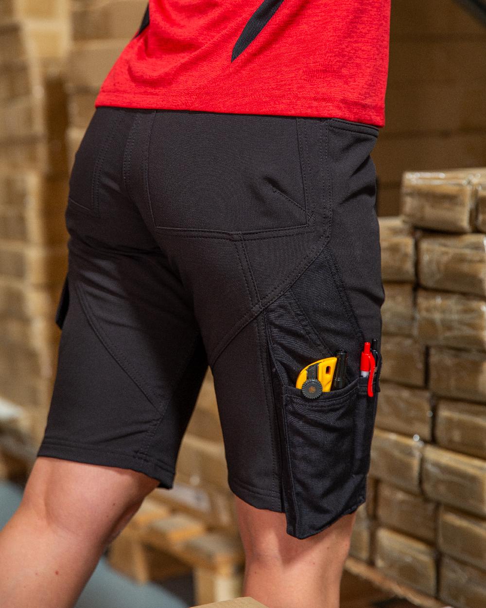 Black Coloured Mascot Workwear Womens Accelerate Diamond Fit Shorts on warehouse background 