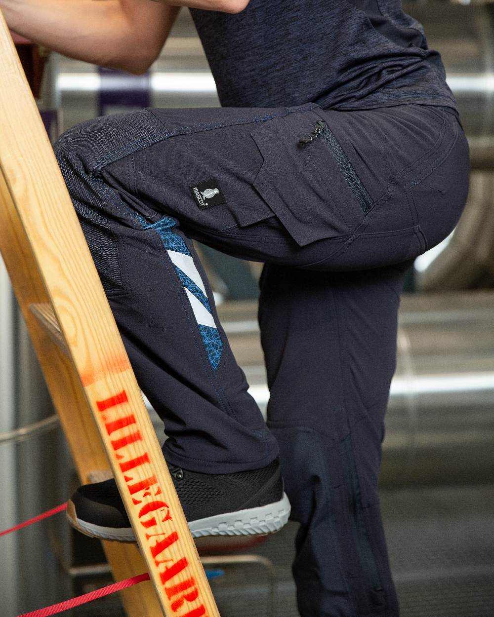 Dark Navy Coloured Mascot Workwear Womens Accelerate Lightweight Trousers With Kneepad Pockets on factory background 