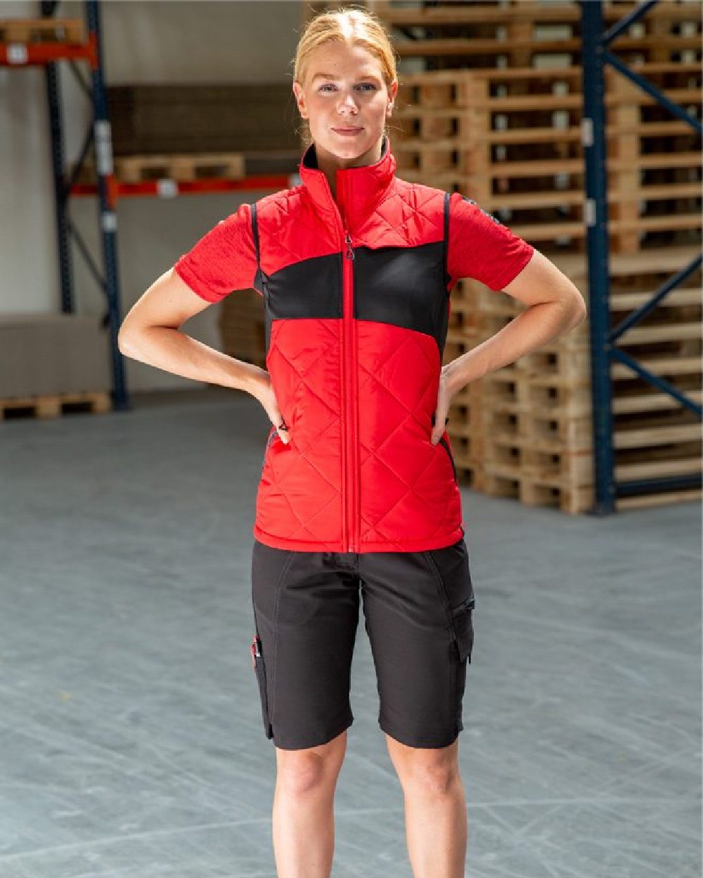 Traffic Red Black Coloured Mascot Workwear Womens Accelerate Thermal Gilet on warehouse background 