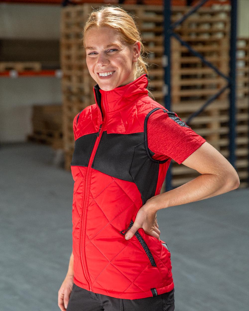 Traffic Red Black Coloured Mascot Workwear Womens Accelerate Thermal Gilet on warehouse background 
