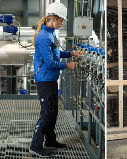 Azure Blue Dark Navy Coloured Mascot Workwear Womens Accelerate Thermal Jacket on factory background 
