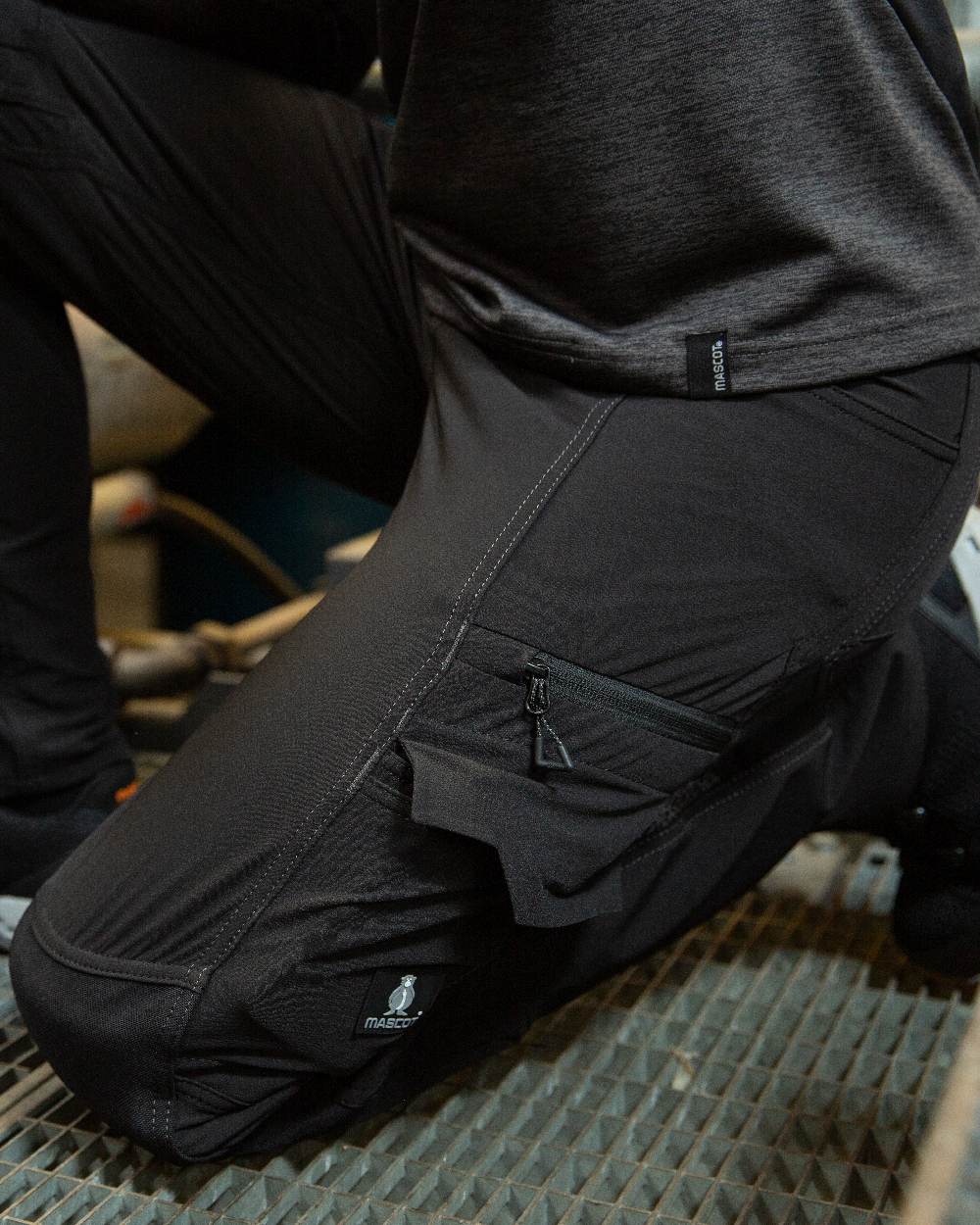 Black Coloured Mascot Workwear Womens Accelerate Trousers With Kneepad Pockets on factory background 