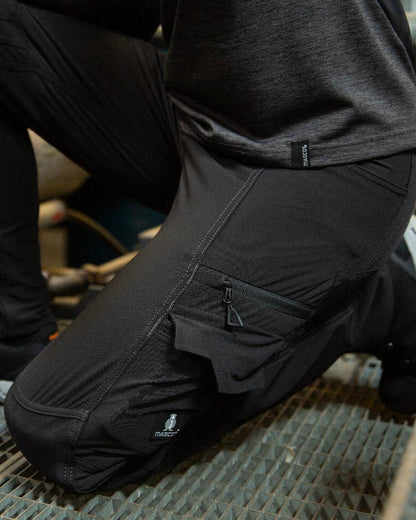 Black Coloured Mascot Workwear Womens Accelerate Trousers With Kneepad Pockets on factory background 
