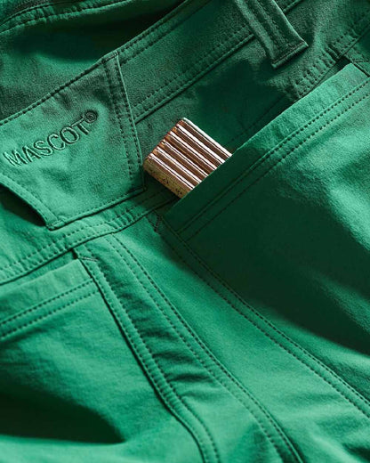 Green Coloured Mascot Workwear Womens Accelerate Trousers With Thigh Pockets on outdoor background 