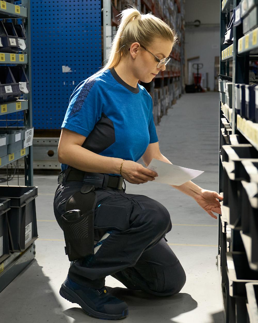 Dark Navy Coloured Mascot Workwear Womens Accelerate Ultimate Stretch Trousers on factory background 