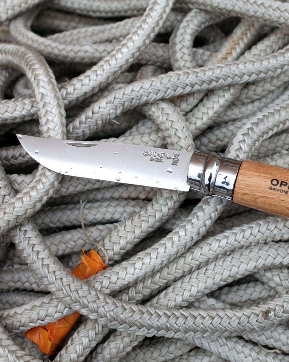 Stainless Steel coloured Opinel Classic Originals Knife on rope background 