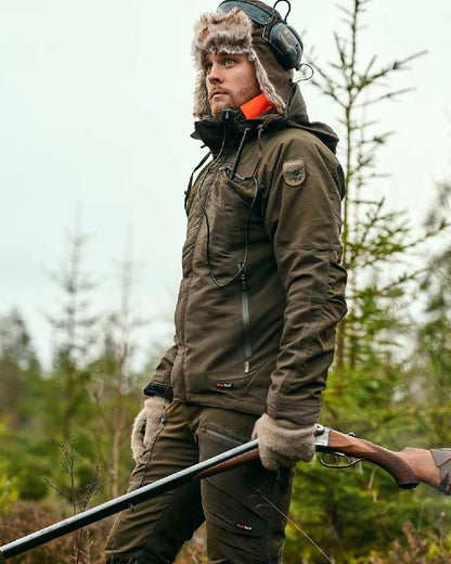 Moss Green coloured Pinewood Mens Hunter Pro Extreme 2.0 Jacket on forest background 