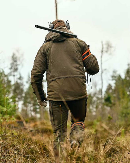Moss Green coloured Pinewood Mens Hunter Pro Extreme 2.0 Jacket on forest background 
