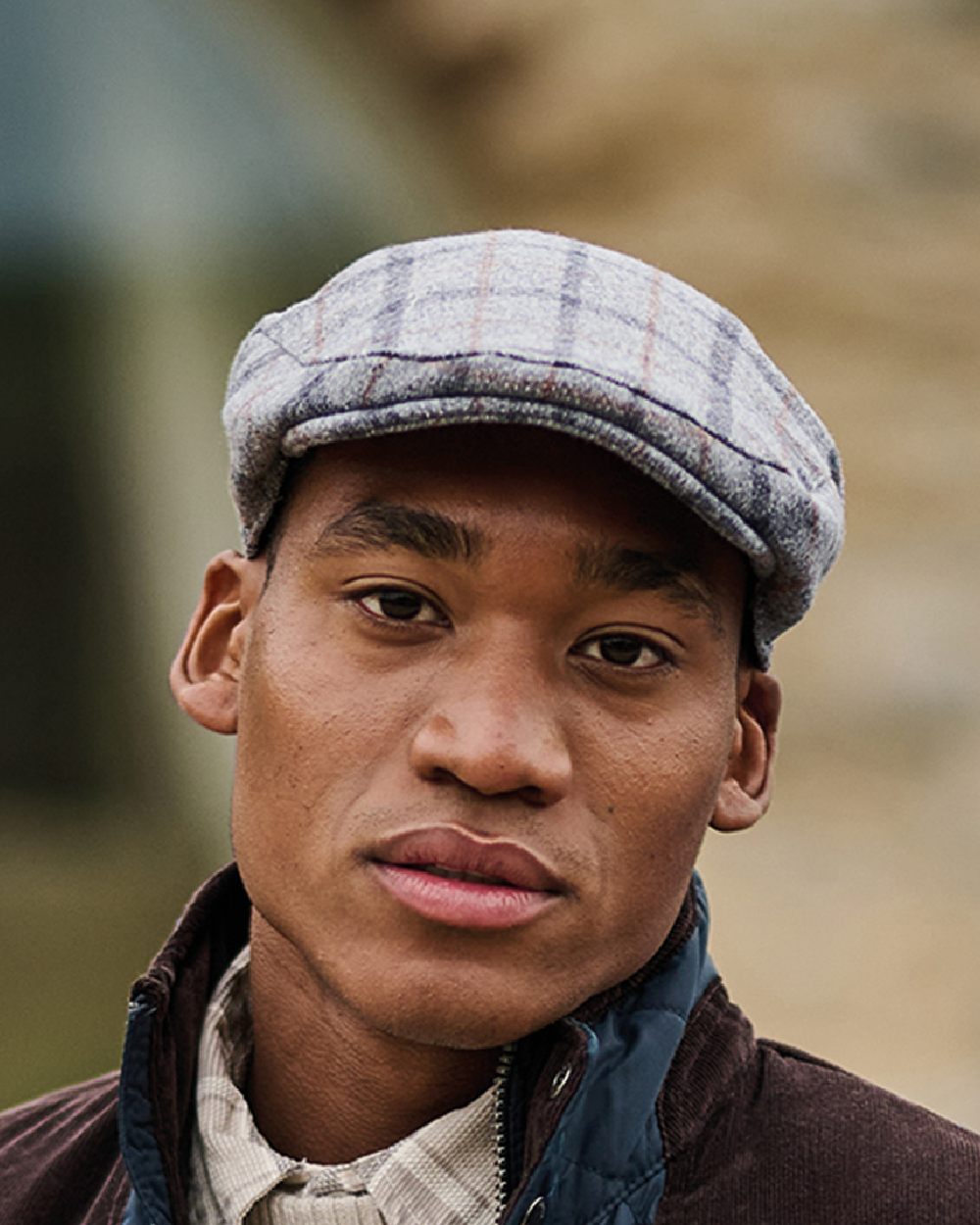 Grey Check coloured Regatta Acre Tweed Flat Cap on blurry background 