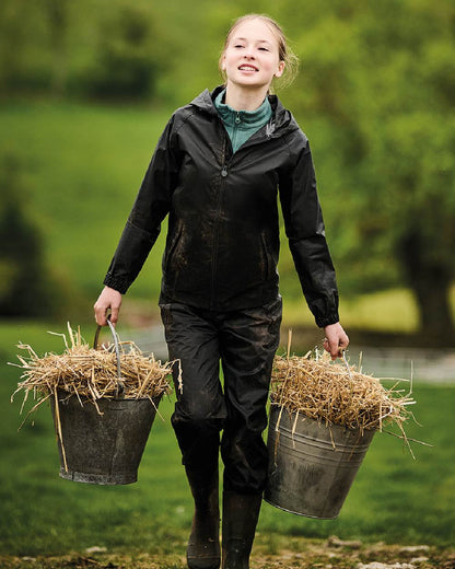 Black coloured Regatta Kids Pro Stormbreak Waterproof Overtrousers on blurry green background 