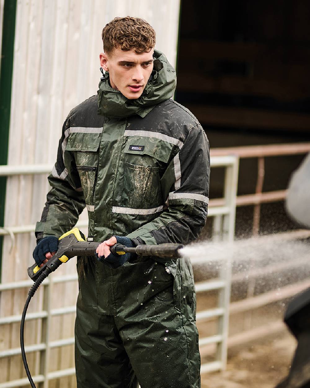 Olive coloured Regatta Pro Waterproof Insulated Coverall on work station background 