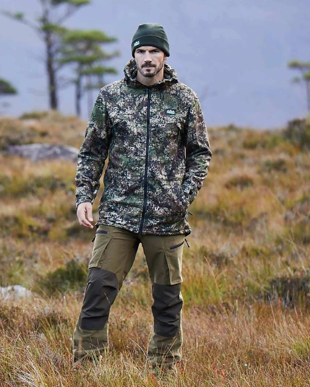 Dirt Camo Ridgeline Grizzly III Jacket on blurry background 