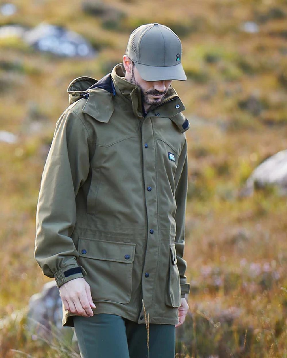 Olive coloured Ridgeline Torrent III Waterproof Jacket on blurry background 