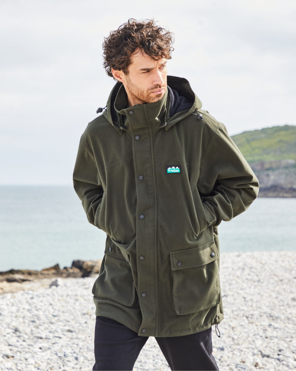 Deep Forest coloured Ridgeline Torrent Waterproof Jacket on beach background 