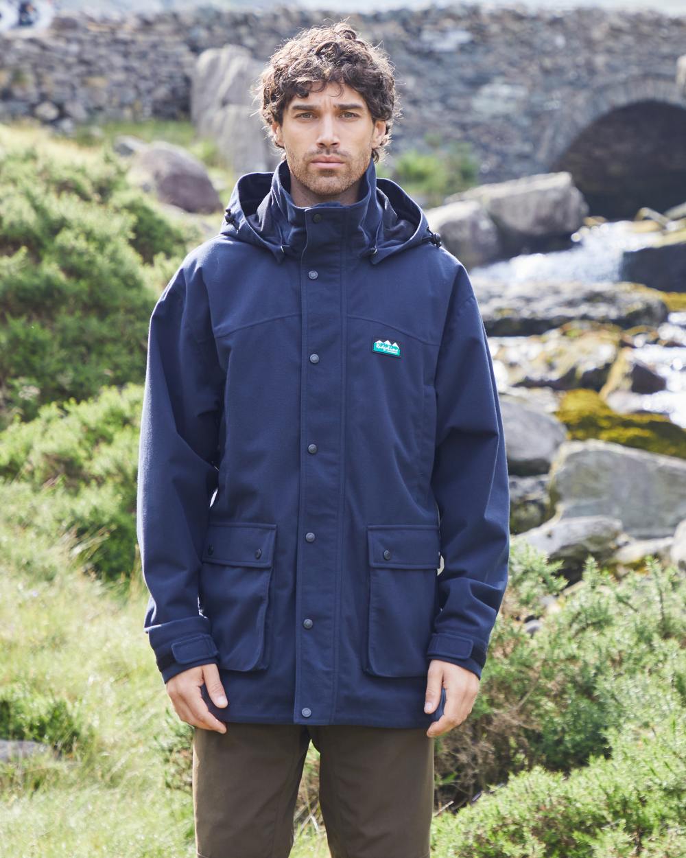 Navy coloured Ridgeline Torrent Waterproof Jacket on hilly background 