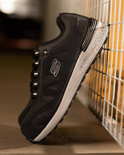Black Coloured Skechers Workwear Mens Bulklin Bragoo Safety Trainers on indoor background 