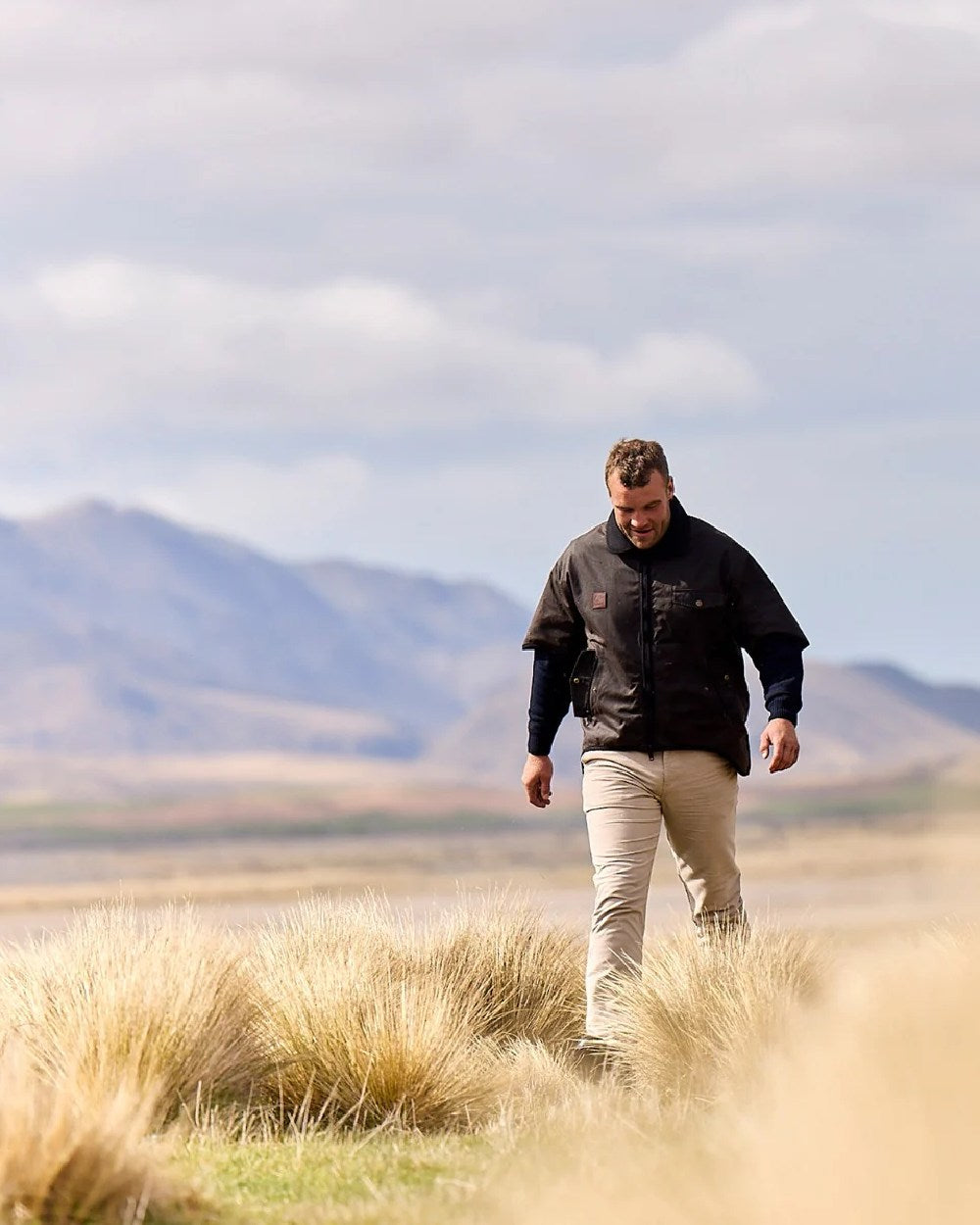 Brown Coloured Swanndri Mens 3/4 Sleeve Oilskin Jacket on field background 