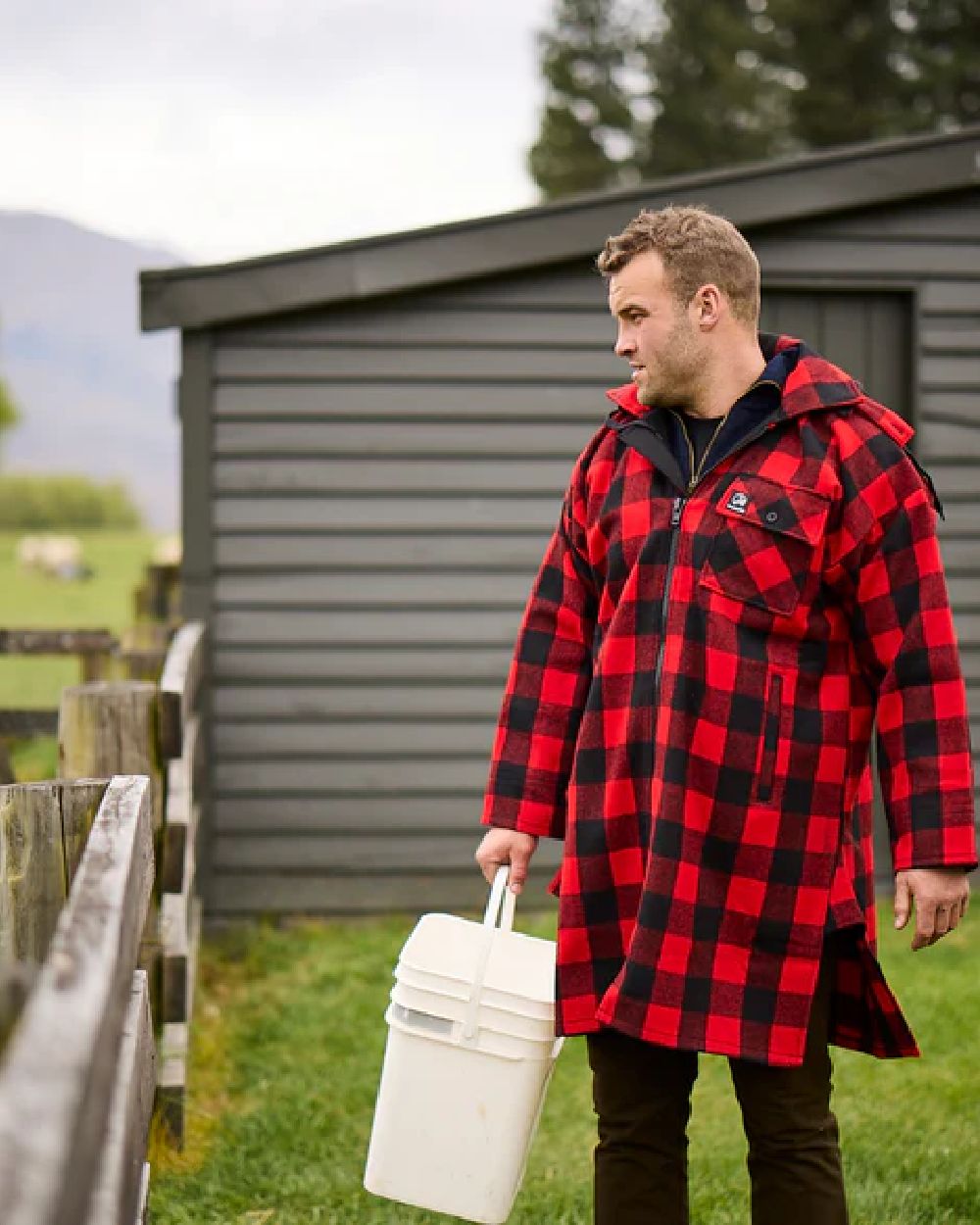 Red Black Check Coloured Swanndri Mens Mosgiel Wool Bushshirt with Zip-up Front on countryside background 