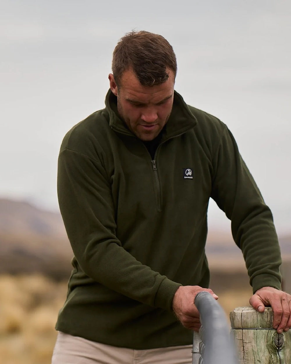 Olive Coloured Swanndri Mens Motu Fleece Pullover on blurry background 