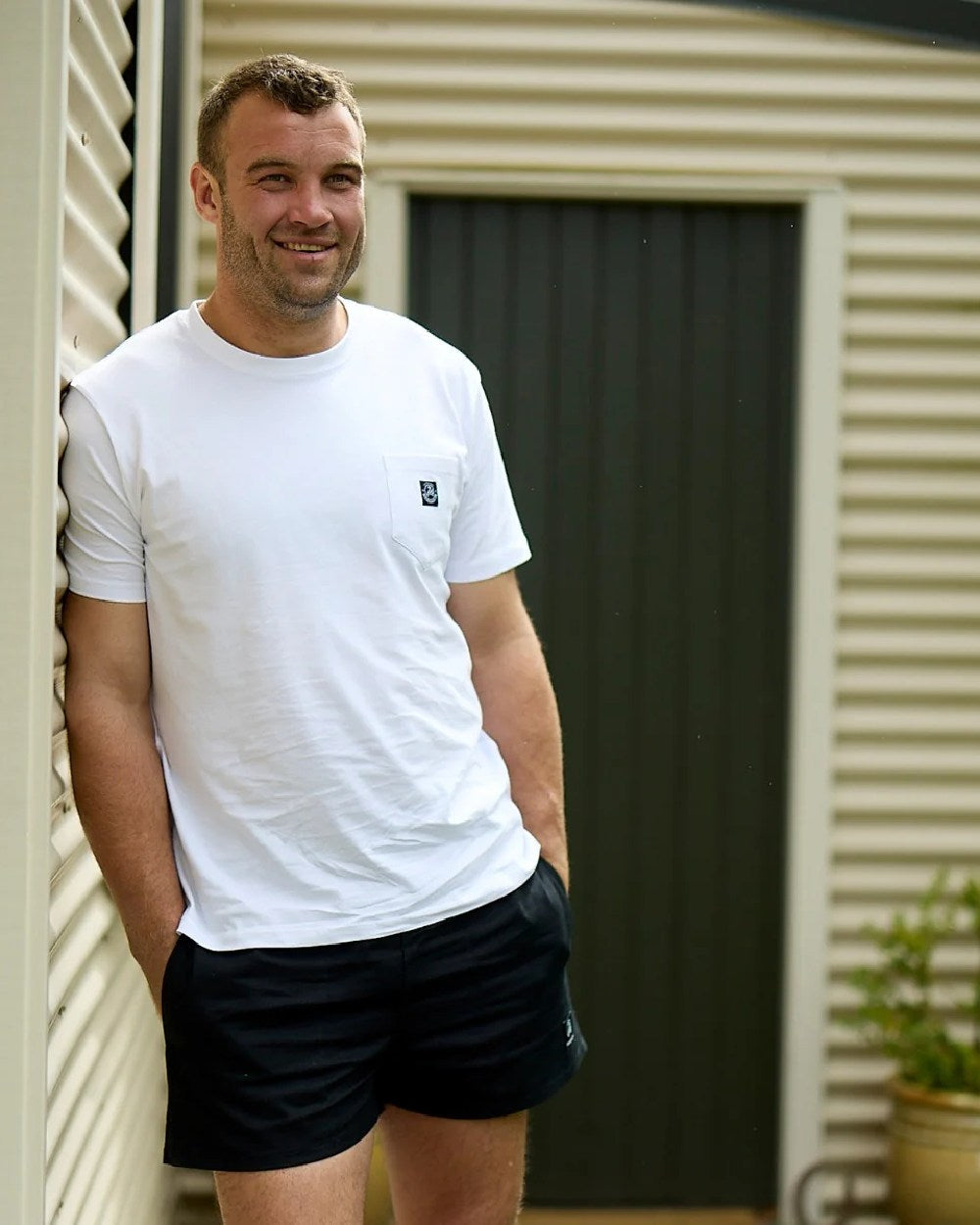 Black Coloured Swanndri Mens Rugby Short on door background 