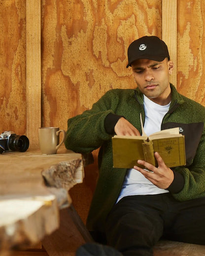 Black Coloured Swanndri Swanni Baseball Cap on cafe background 