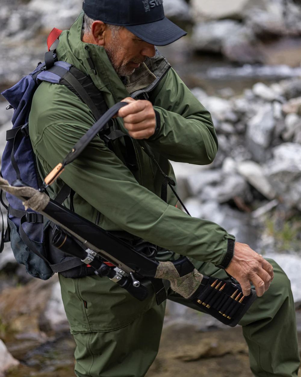 Olive coloured Swazi Mens Rifleman Ultralite Overpants on rock background 