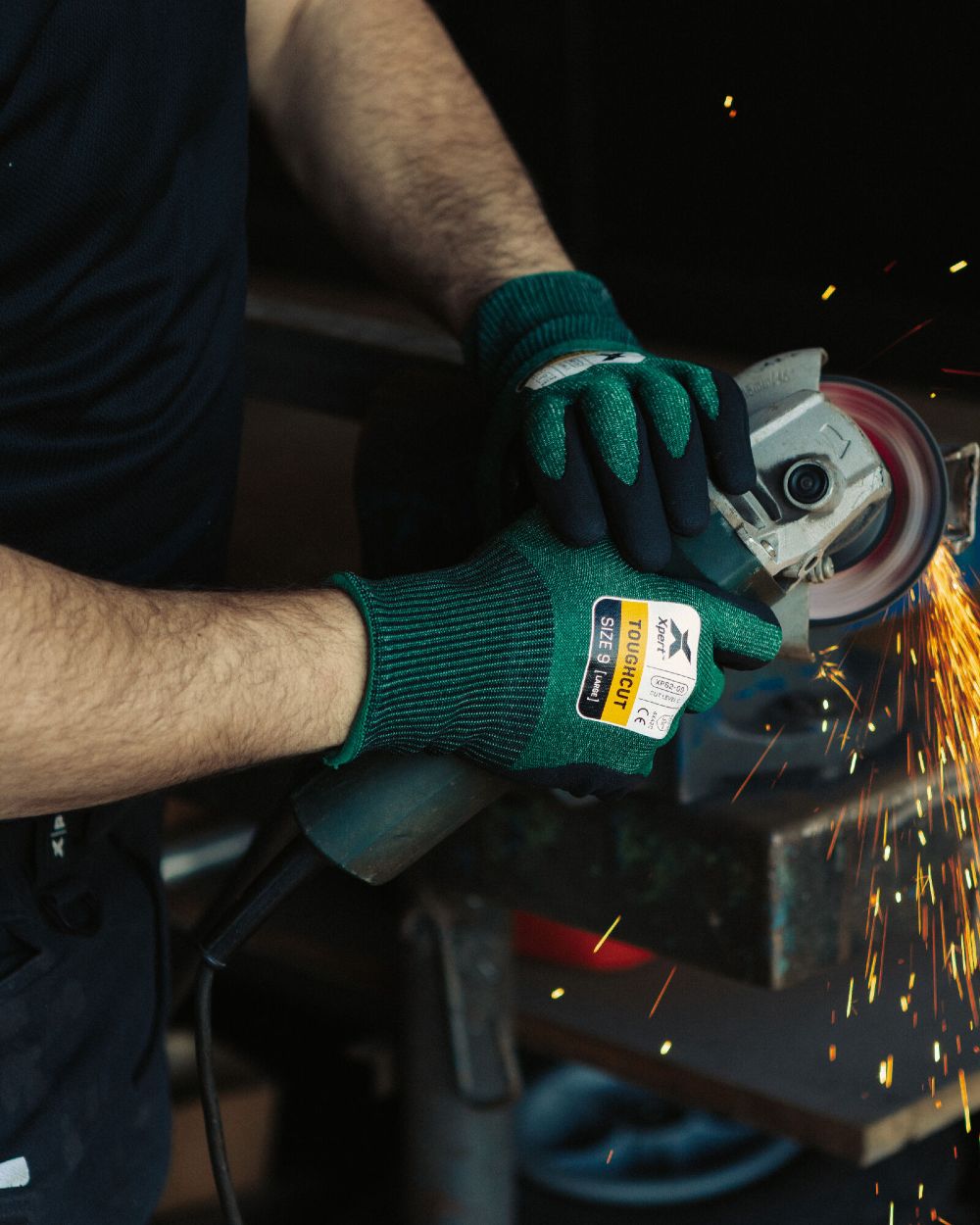 Green Black coloured Xpert Core Toughcut Level C Cut Resistant Dexterous Gloves on garage background 