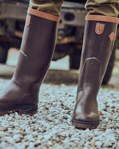 Dark Brown Coloured Aigle Parcours 2 Signature Wellingtons On A Forest Background 