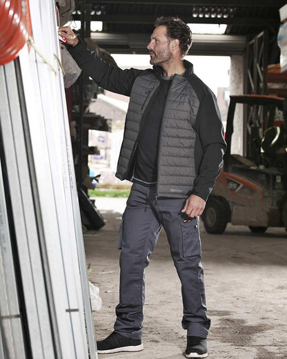 Grey Coloured TuffStuff Pro Work Trousers On A Warehouse Background 